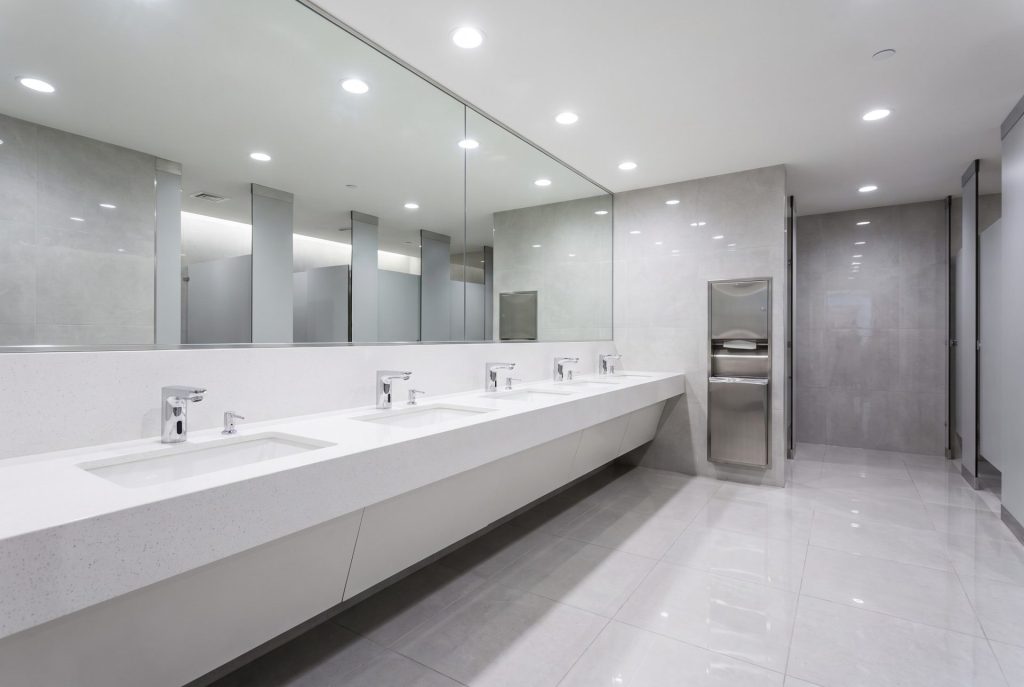 Spotless commercial restroom with clean sinks and mirror in a high-traffic office building