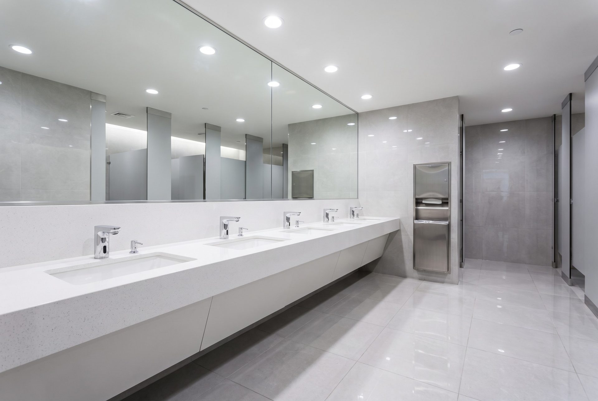 Spotless commercial restroom with clean sinks and mirror in a high-traffic office building
