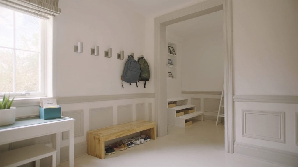 Organized home mudroom entryway with backpack hooks and shoe bench, set up for a back-to-school cleaning routine